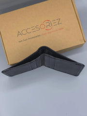 Black wallet in front of a brown box with 'ACCESORIEZ' branding.