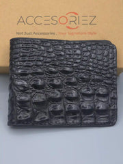 Black crocodile-patterned wallet on a light gray surface with 'Accesoriez' branding in the background.