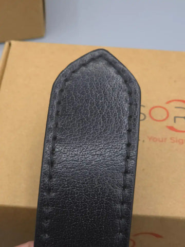 Black leather sheath on a cardboard box with visible branding
