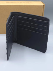 Black leather wallet on a white surface with a cardboard box in the background