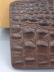 Brown leather wallet with crocodile texture on a white background