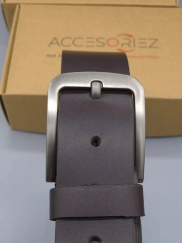 Brown leather belt with silver buckle in front of an Accesoriz box.