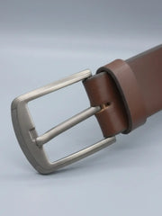 Brown leather belt with a silver buckle on a light gray background