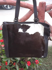 Black and white cowhide handbag with floral background