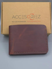 Brown leather wallet in front of a 'Accesoriez' branded box on a gray background