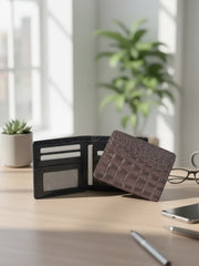 Black wallet and brown cardholder on a desk with a plant and glasses in the background