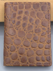 Brown leather wallet with crocodile texture on a gray background
