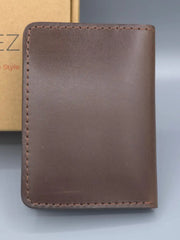 Brown leather wallet on a gray background