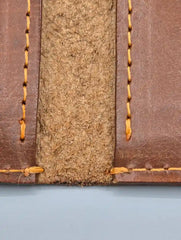 Close-up of a leather-bound book with visible stitching on a light blue background