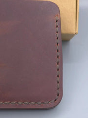Close-up of a brown leather wallet with visible stitching on a light gray background