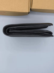 Black wallet on a light gray surface with a cardboard box in the background