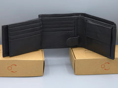 Black leather wallet on a cardboard box with a gray background