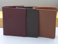 Three leather wallets in different colors on a light background