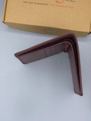 Brown wallet on a white surface with a brown box in the background