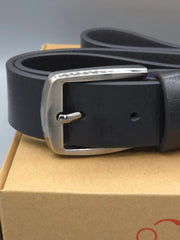 Black leather belt with silver buckle on a cardboard box