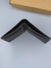 Black wallet on a light gray surface with a cardboard box in the background