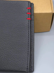 Black leather notebook with red stitching on a white background