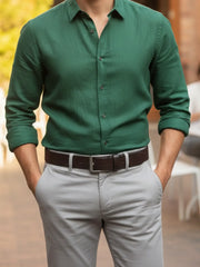 Person wearing a green shirt and gray pants with a blurred background