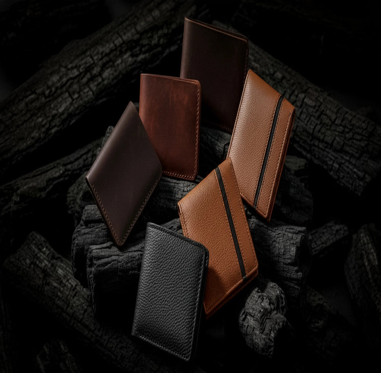 Collection of leather wallets in various colors on a dark textured surface
